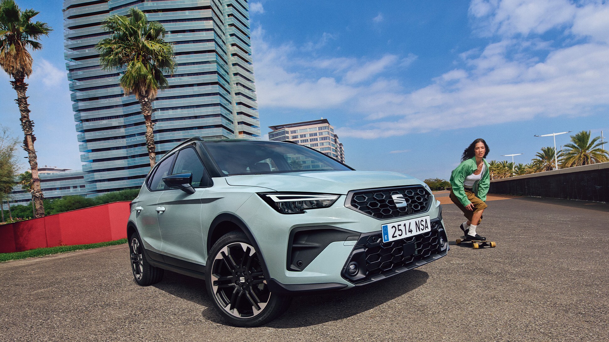 SEAT Arona parked on a sunny urban street with modern buildings and a skater passing by
