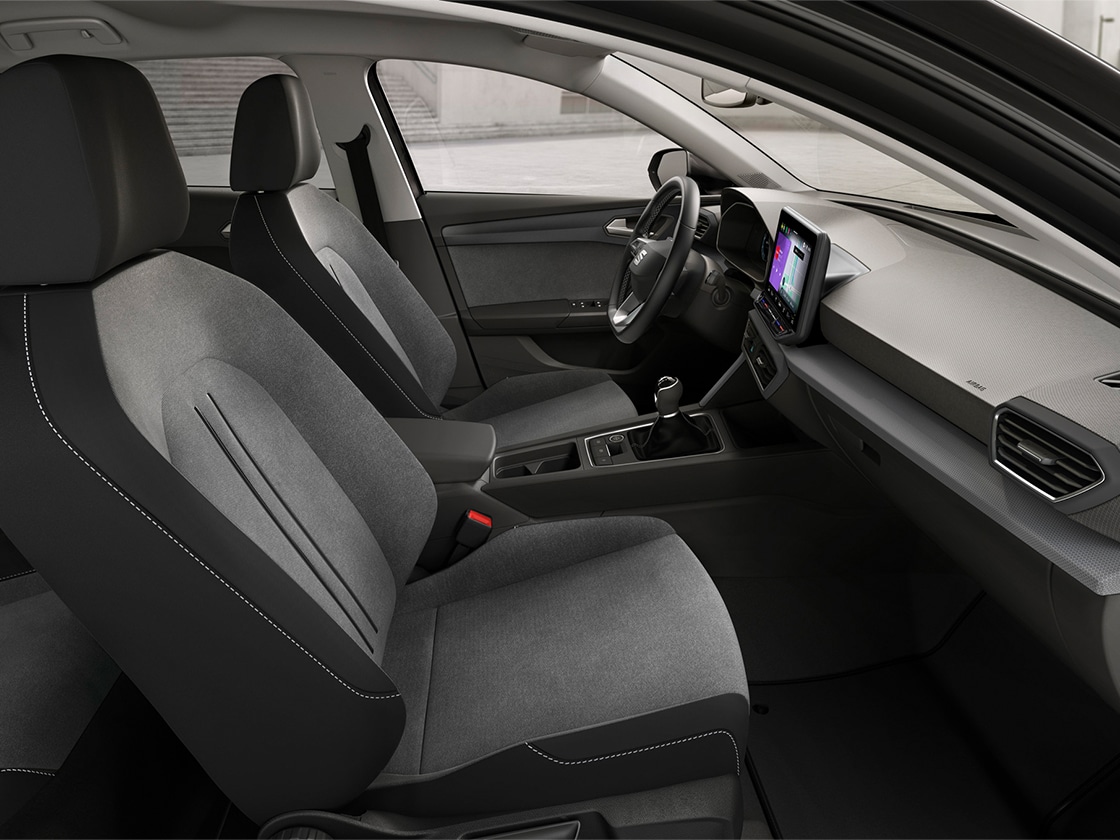 SEAT Leon hatchback 2025 plug in hybrid electric vehicle. Parked and charging outdoors, featuring spoke alloy wheels, interior ambient lighting and heated front seats for optimal comfort.