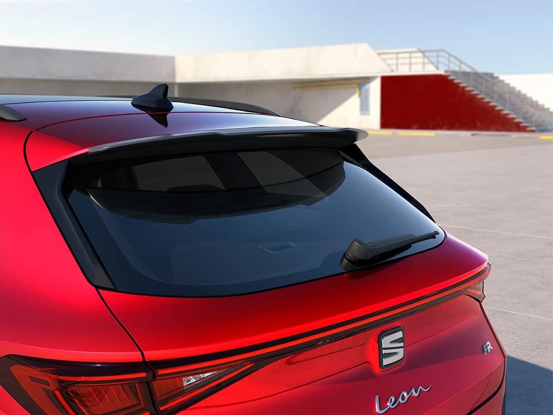 Rear view of the seat leon fr automatic car charging at a station, a new hatchback for 2025 in magnetic grey, complete with rear parking sensors and led headlights and taillights.