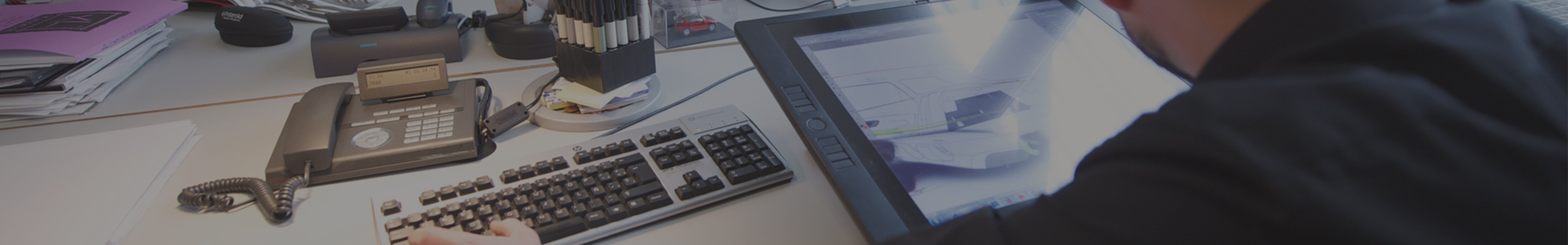 View behind a deak worker’s shoulder with a smart tablet on the desk – SEAT Human Resources